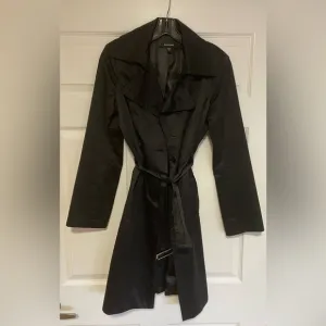 BEBE Black Belted Trench Coat Super Unique and Versatile Size Medium.